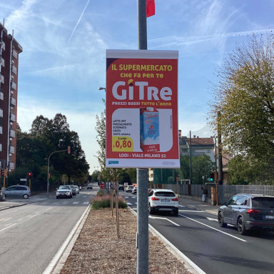 Gonfalone pubblicitario palo luce su strada a Lodi