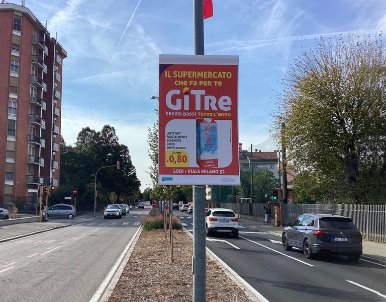 Gonfalone pubblicitario palo luce su strada a Lodi